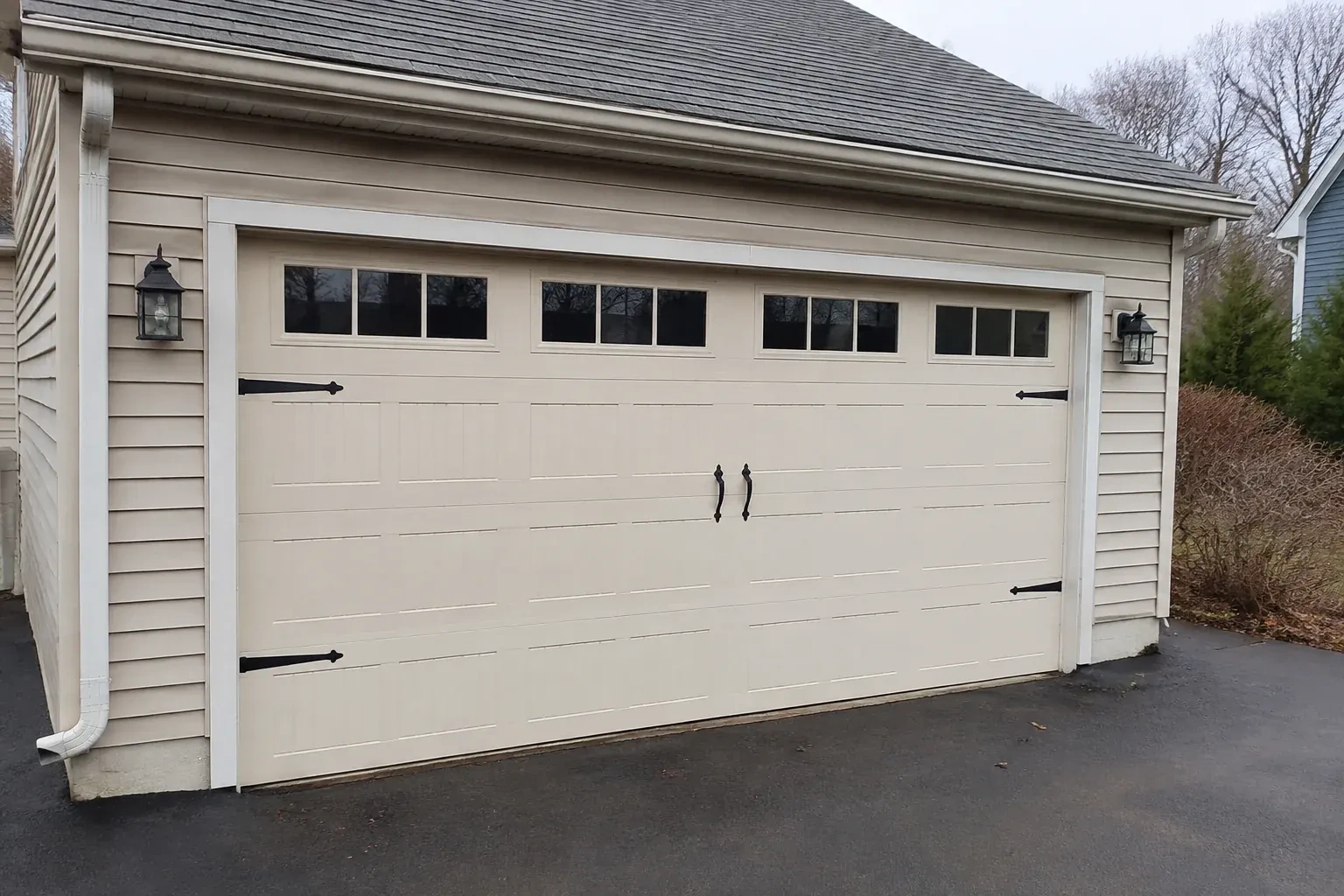 Cream carriage-house-style garage door with dark decorative hardware. — Carriage-House Garage Door Installation, Mississauga